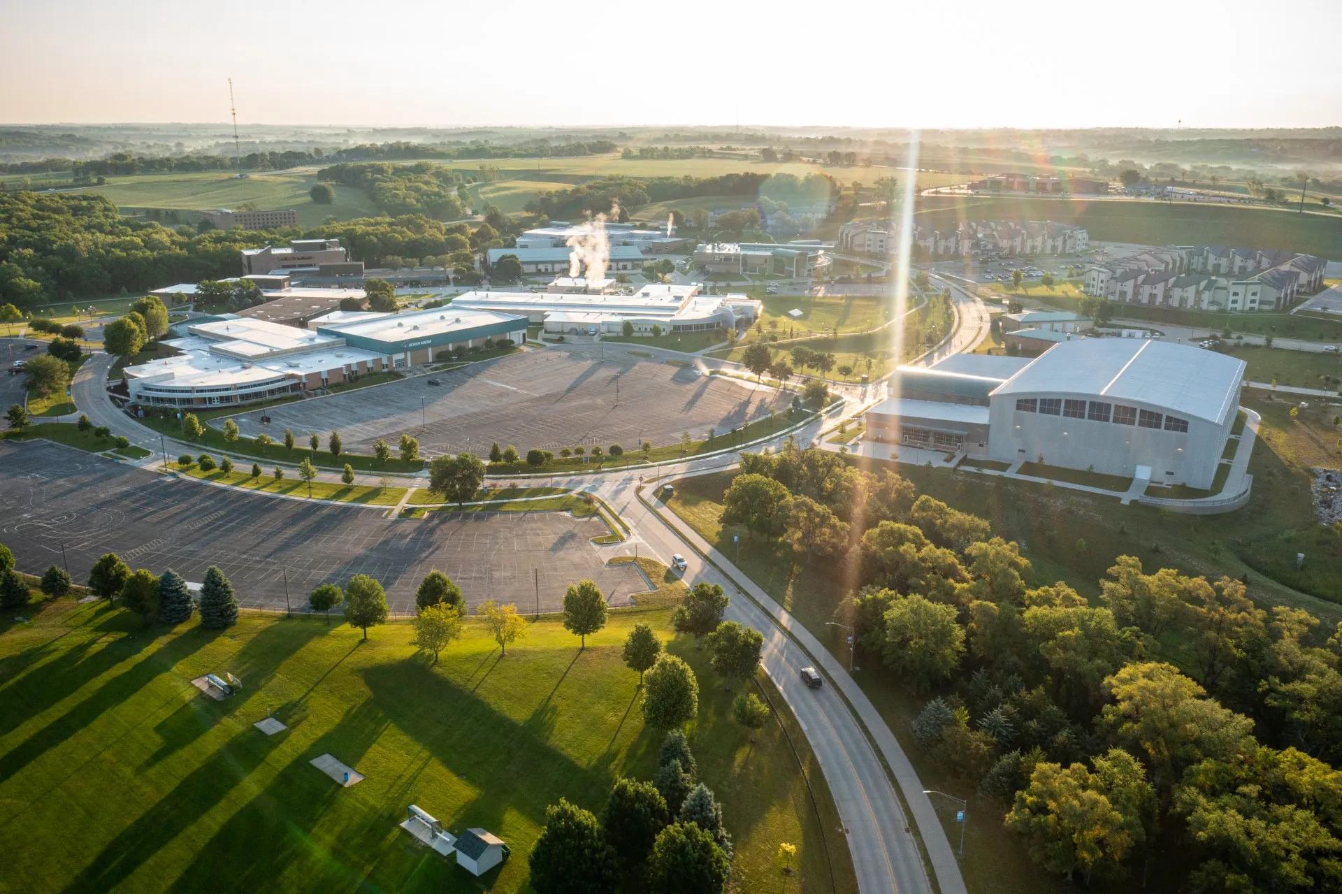 Aerial view at sunrise of a sprawling suburban campus featuring connected low-rise buildings